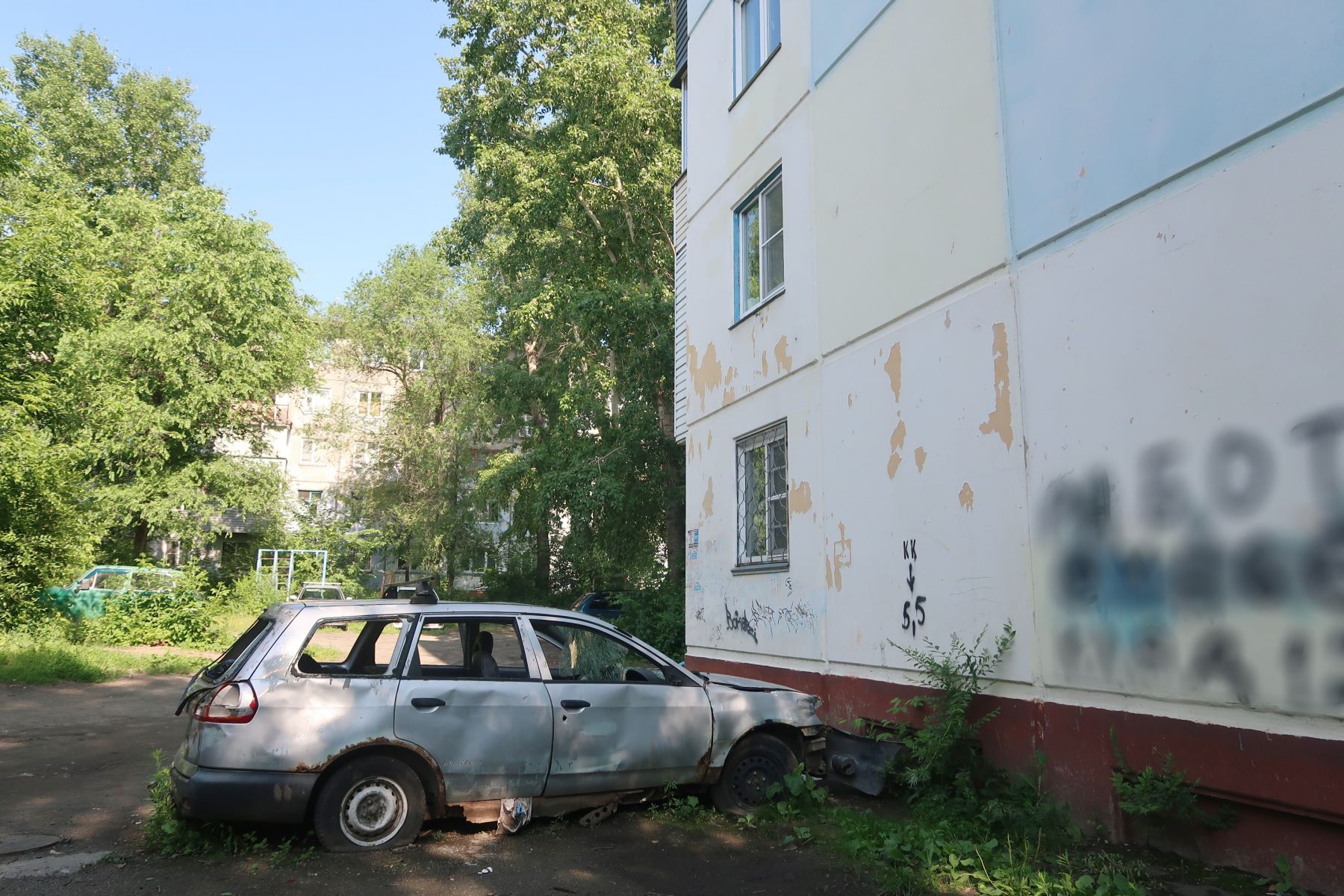 Заброшенный автомобиль стоит очень близко к жилому дому 