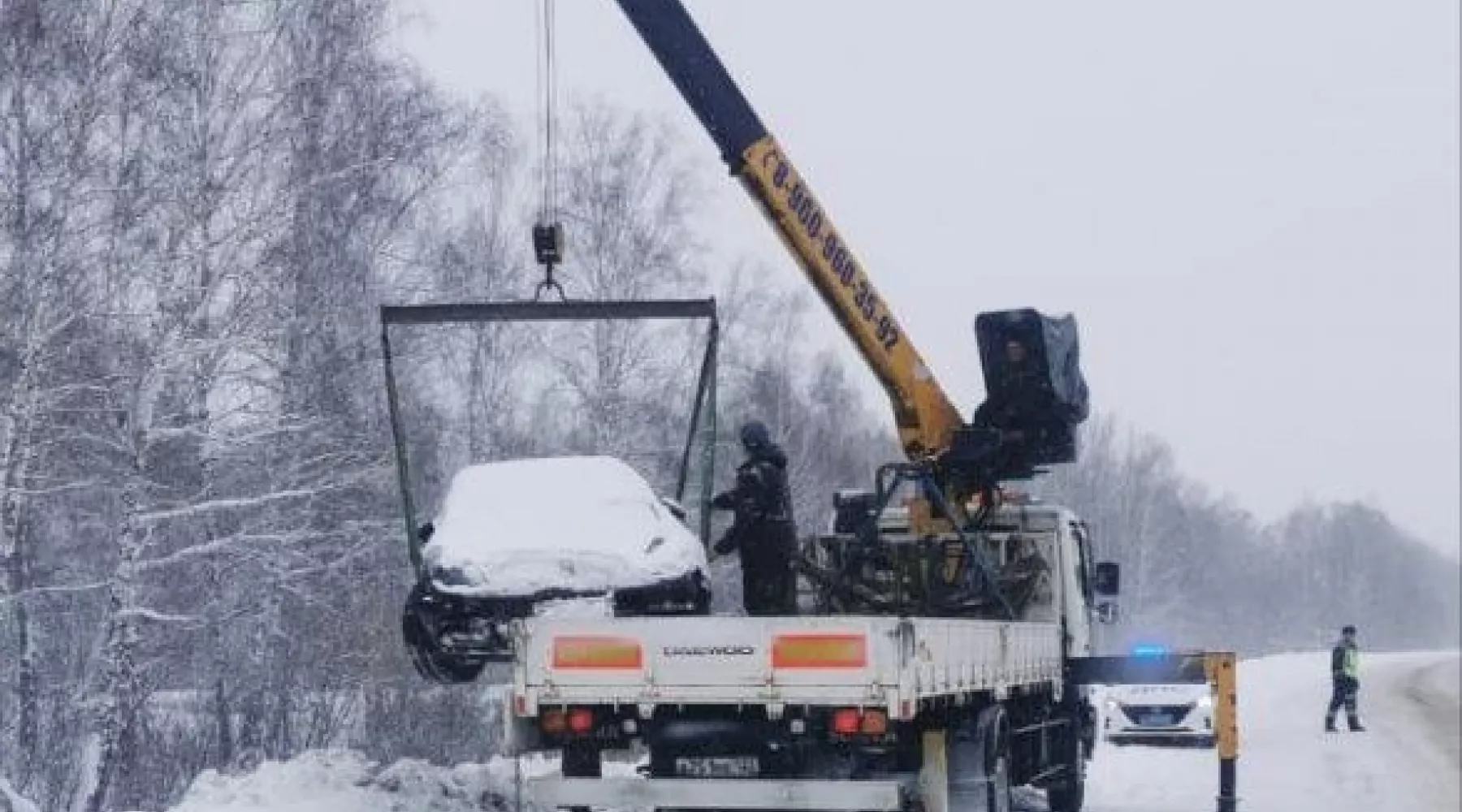 Автомобиль вытаскивают краном из сугроба